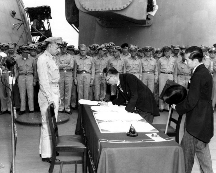 Japanese Foreign Minister Mamoru Shigemitsu signs the Instrument of Surrender on behalf of the Japanese Government.